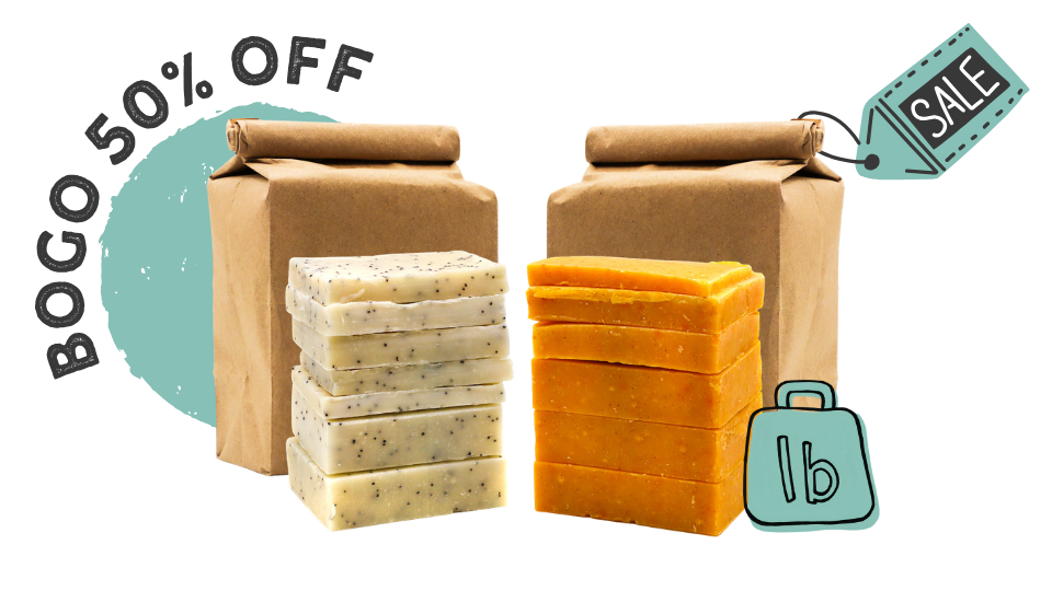 Two brown paper mailers with stacked bars of soap in front, one pale speckled soap and one orange-yellow soap, on a white background with 'BOGO 50% OFF' and a 'SALE' tag graphic.