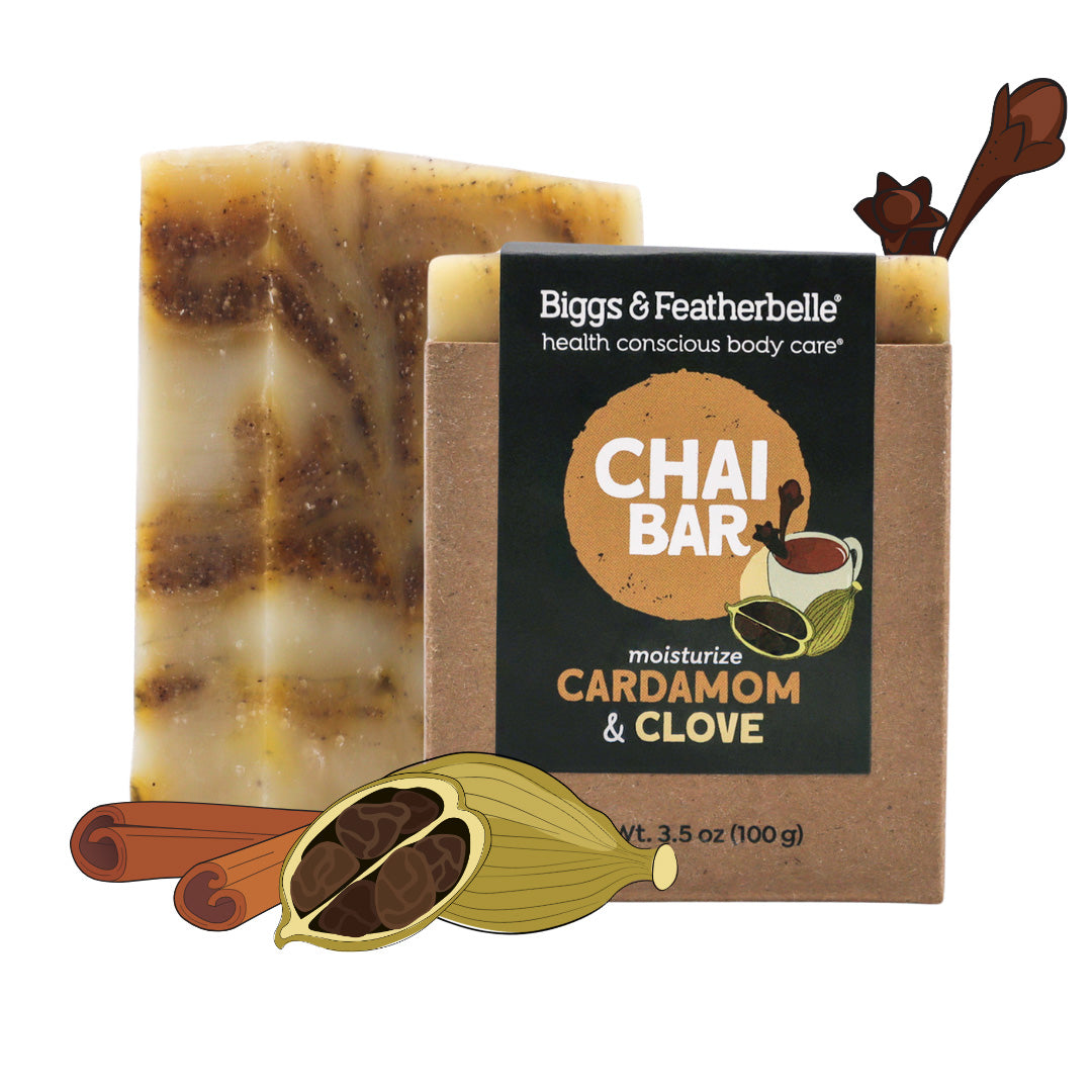 Biggs & Featherbelle Chai Bar soap in Cardamom & Clove scent, shown with its kraft paper packaging box and decorative illustrations of cinnamon sticks and a cardamom pod on a white background.